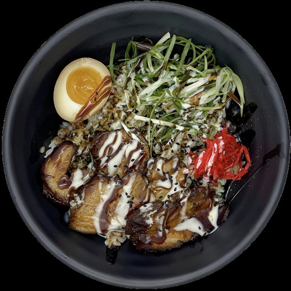 Loaded black bowl of grilled meat topped with creamy and brown sauces, sesame seeds, scallions, red pepper, and dipping sauce.
