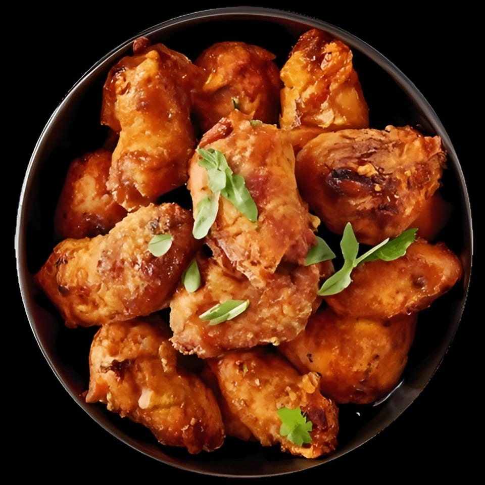 Plate of golden-brown fried pastries garnished with fresh green herbs against a black background.